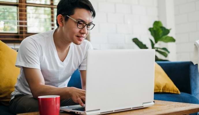 식사를 하면서 휴대폰으로 Norton 360 Standard를 실행 중인 남성.